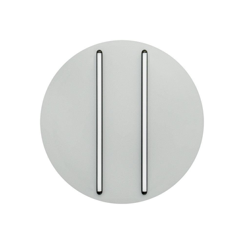 Vue de face du luminaire rond, deux longs diffuseurs noirs verticaux.