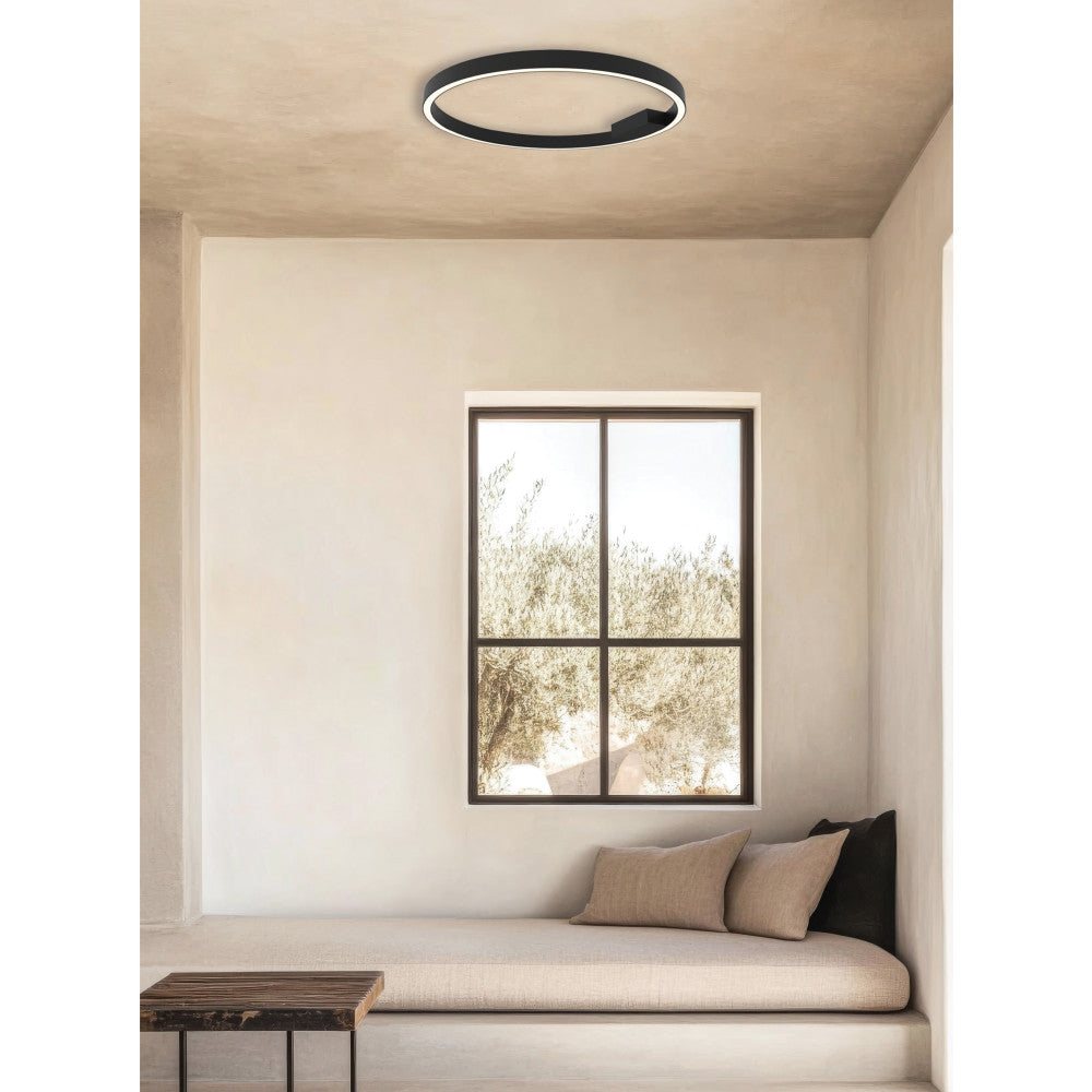 Plafonnier rond noir installé sur plafond beige, pièce style méditerranéen