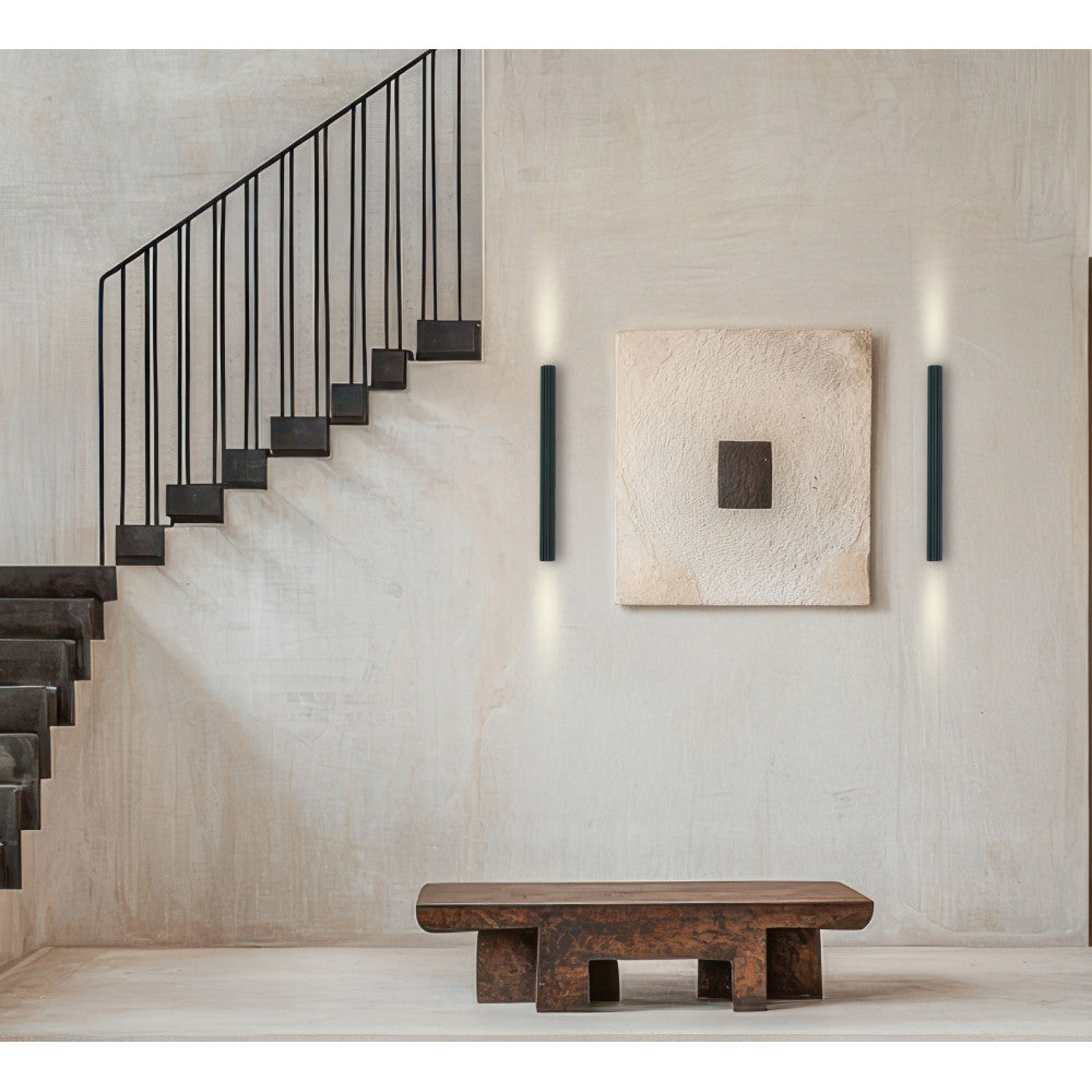 Mise en ambiance dans un escalier béton avec deux appliques murales verticales allumées