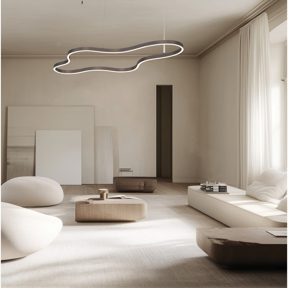 Mise en ambiance dans un salon épuré, luminaire suspendu au-dessus du mobilier beige clair