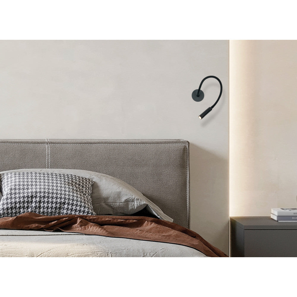 Mise en ambiance chambre avec applique murale noire au-dessus de la tête de lit.