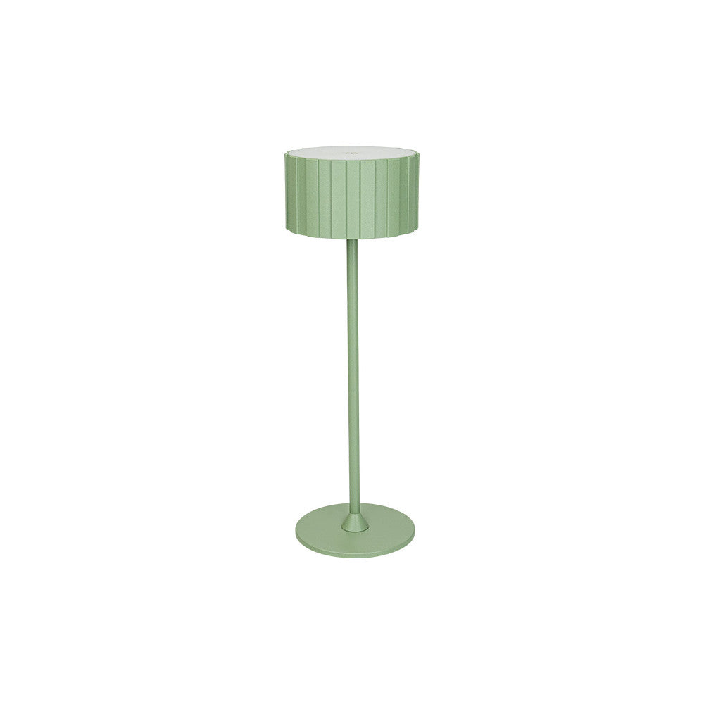 Lampe verte de face sur fond blanc, abat-jour cylindrique nervuré et pied fin sur socle rond