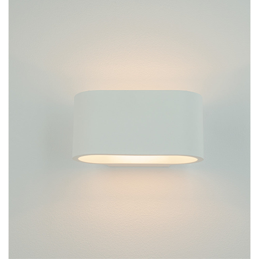 Applique fixée au mur diffusant une lumière chaude vers le haut et le bas