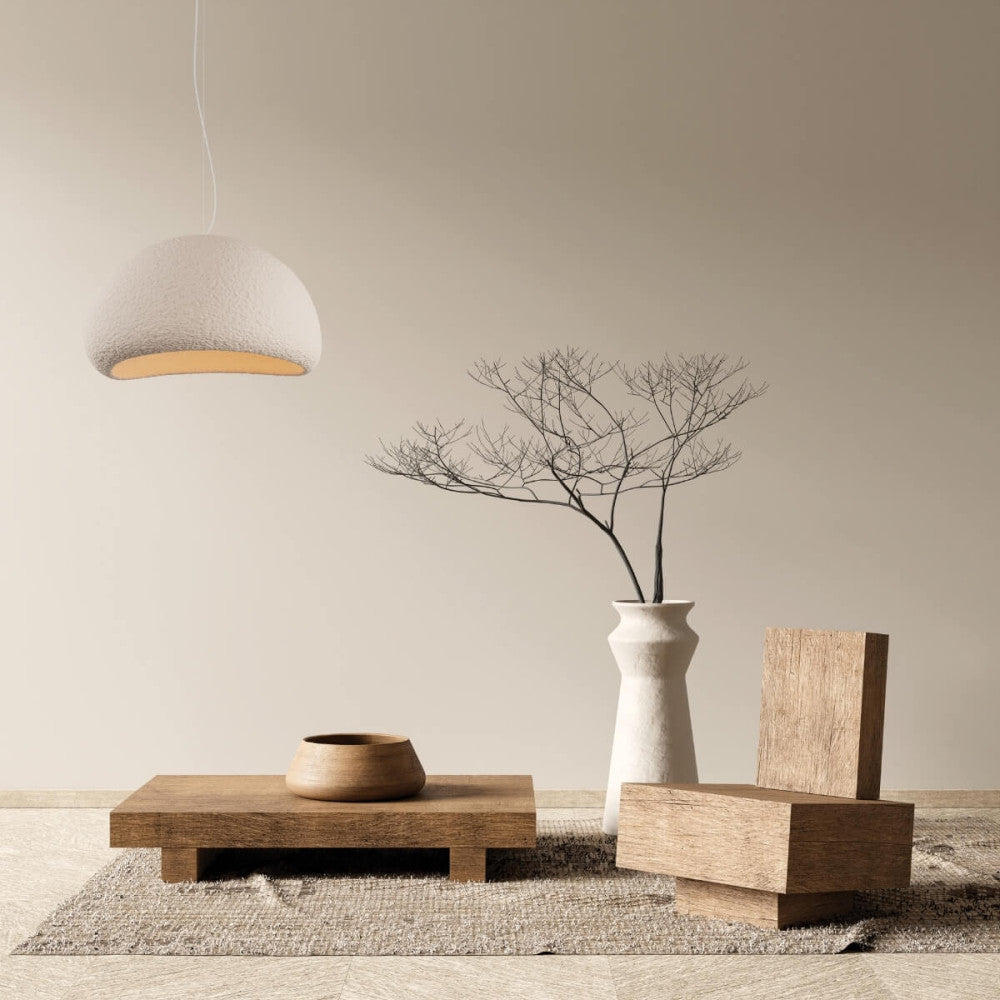 Mise en ambiance salon minimaliste, suspension allumée au-dessus d'une table basse en bois