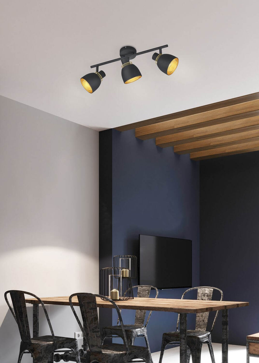 Spot trois lumières orientables monté au plafond, éclairant une salle à manger au mur bleu