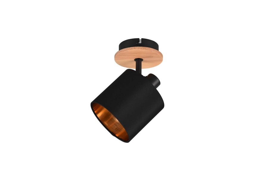 Projecteur sur plafond avec platine en bois clair, corps noir et réflecteur cuivré.