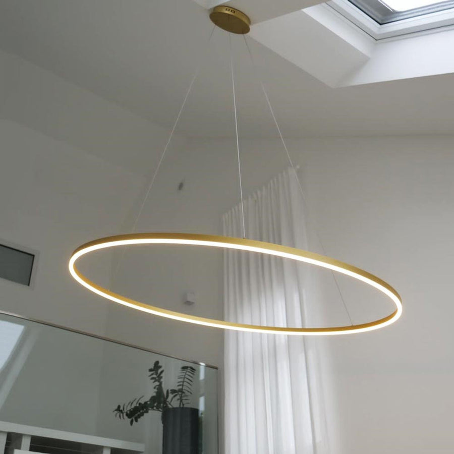 Gros plan sur l'anneau doré lumineux suspendu sous un velux blanc