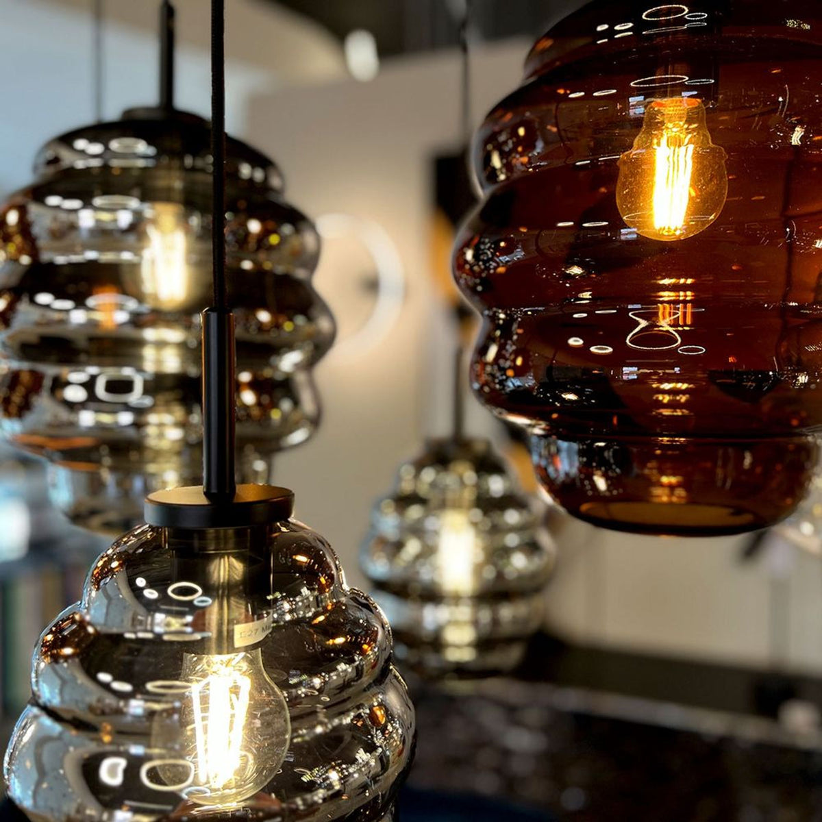 Détail rapproché des verres ambré et fumé avec ampoules à filament visibles