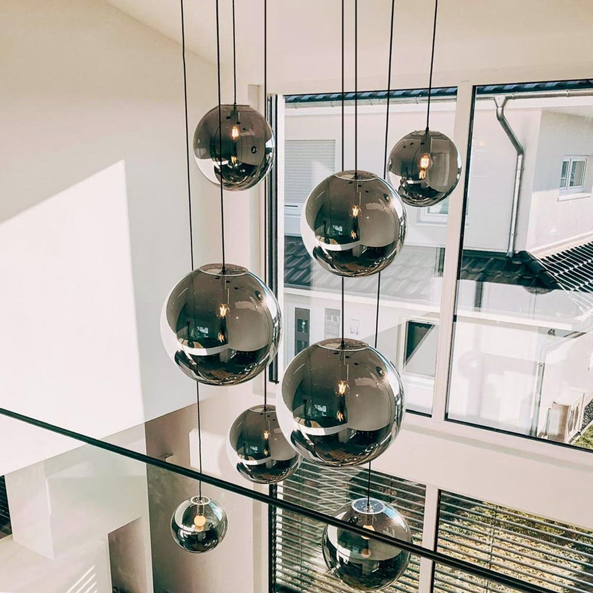 Suspension à huit boules de verre fumé suspendues devant de grandes baies vitrées