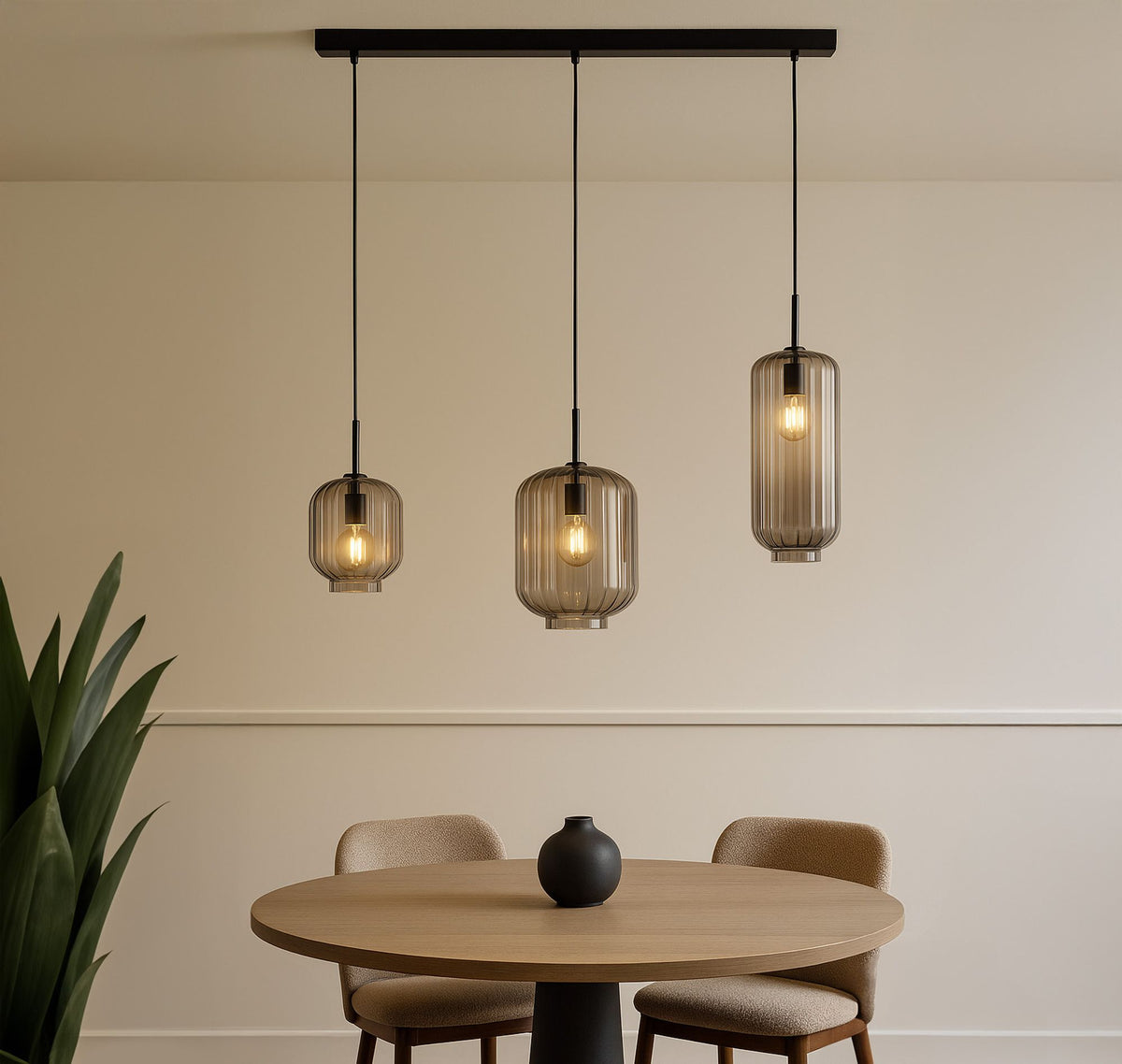 Suspension trois lumières en ambiance salle à manger, table ronde en bois et verres fumés