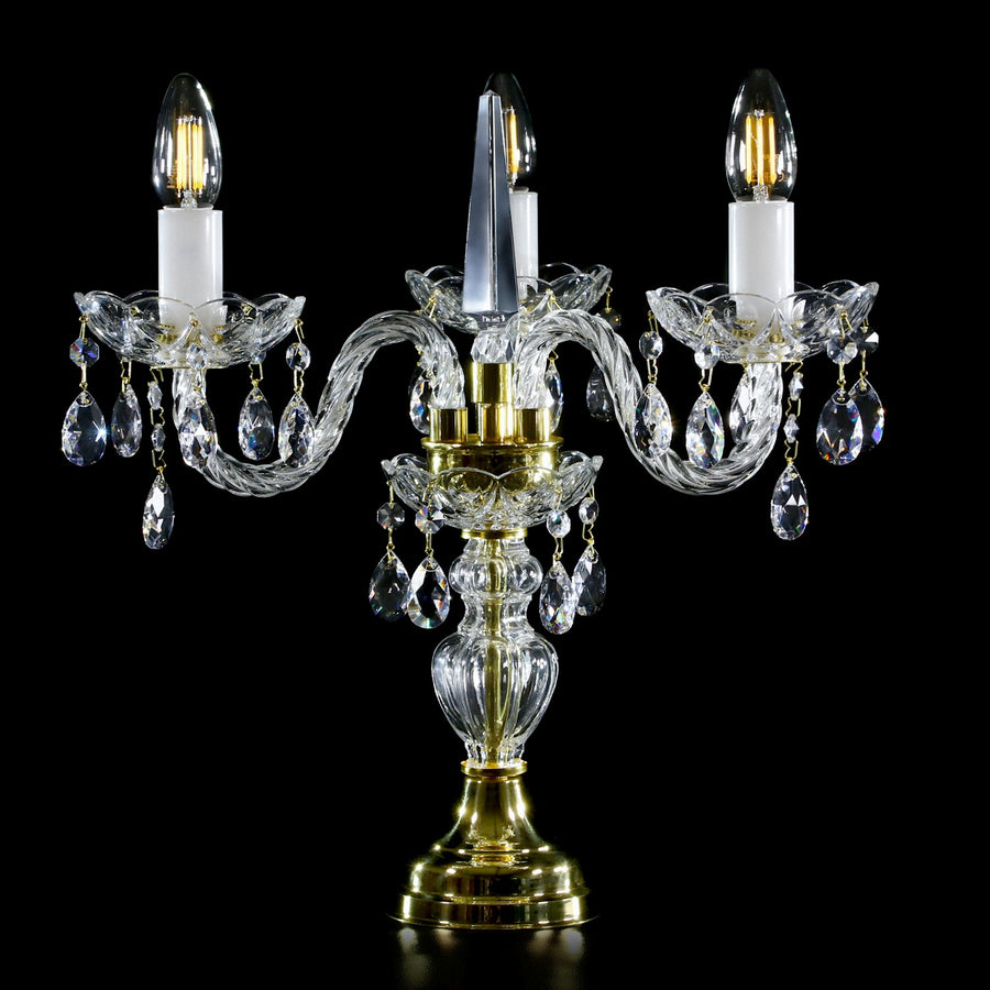 Même luminaire vu de face avec monture dorée et bougeoirs blancs, détails du cristal taillé