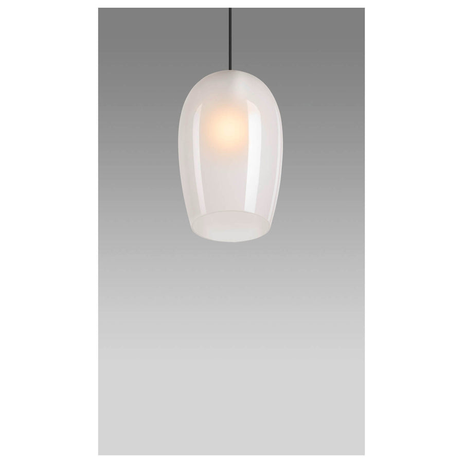 Suspension allumée dans une pièce grise, diffusant une lumière chaude à travers le verre dépoli.