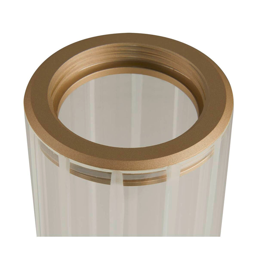 Gros plan sur la bague en laiton et les stries du verre cylindrique.