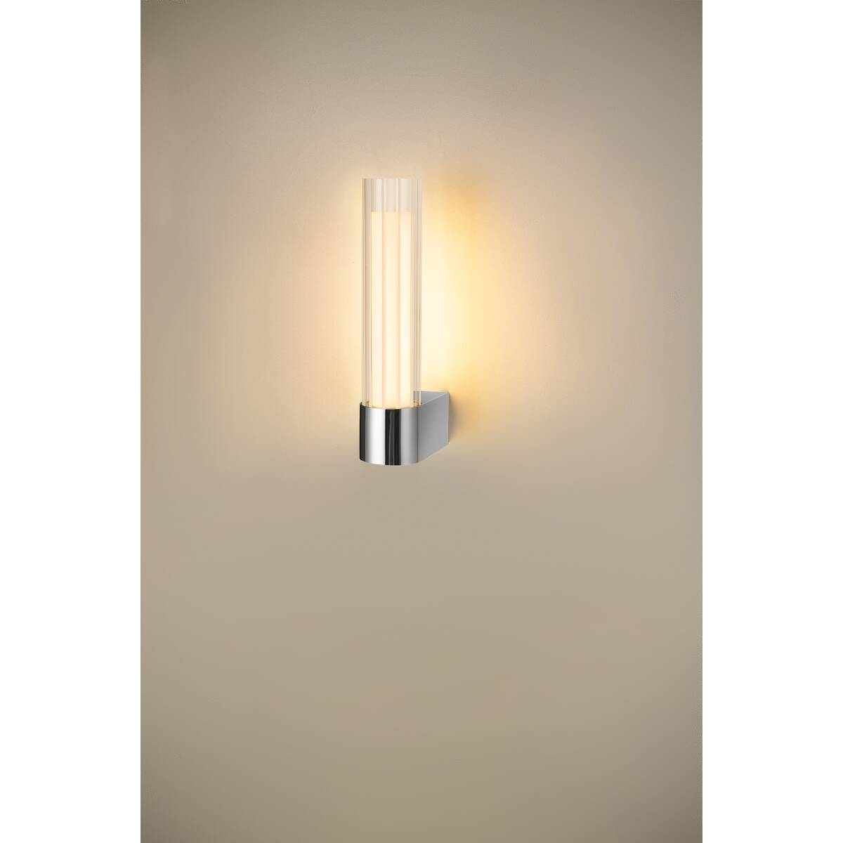Mise en ambiance de l'applique diffusant une lumière chaude sur un mur beige.