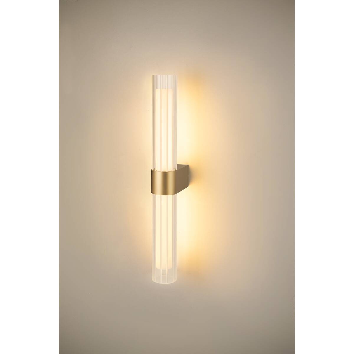 Mise en ambiance nocturne montrant l'applique allumée projetant une lumière chaude sur le mur