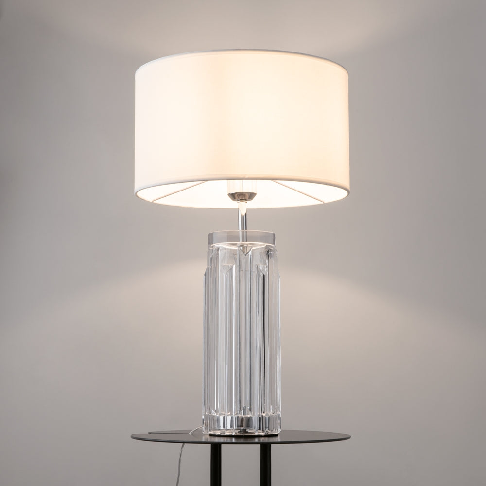 Lampe posée sur une table noire dans un intérieur gris, lumière allumée