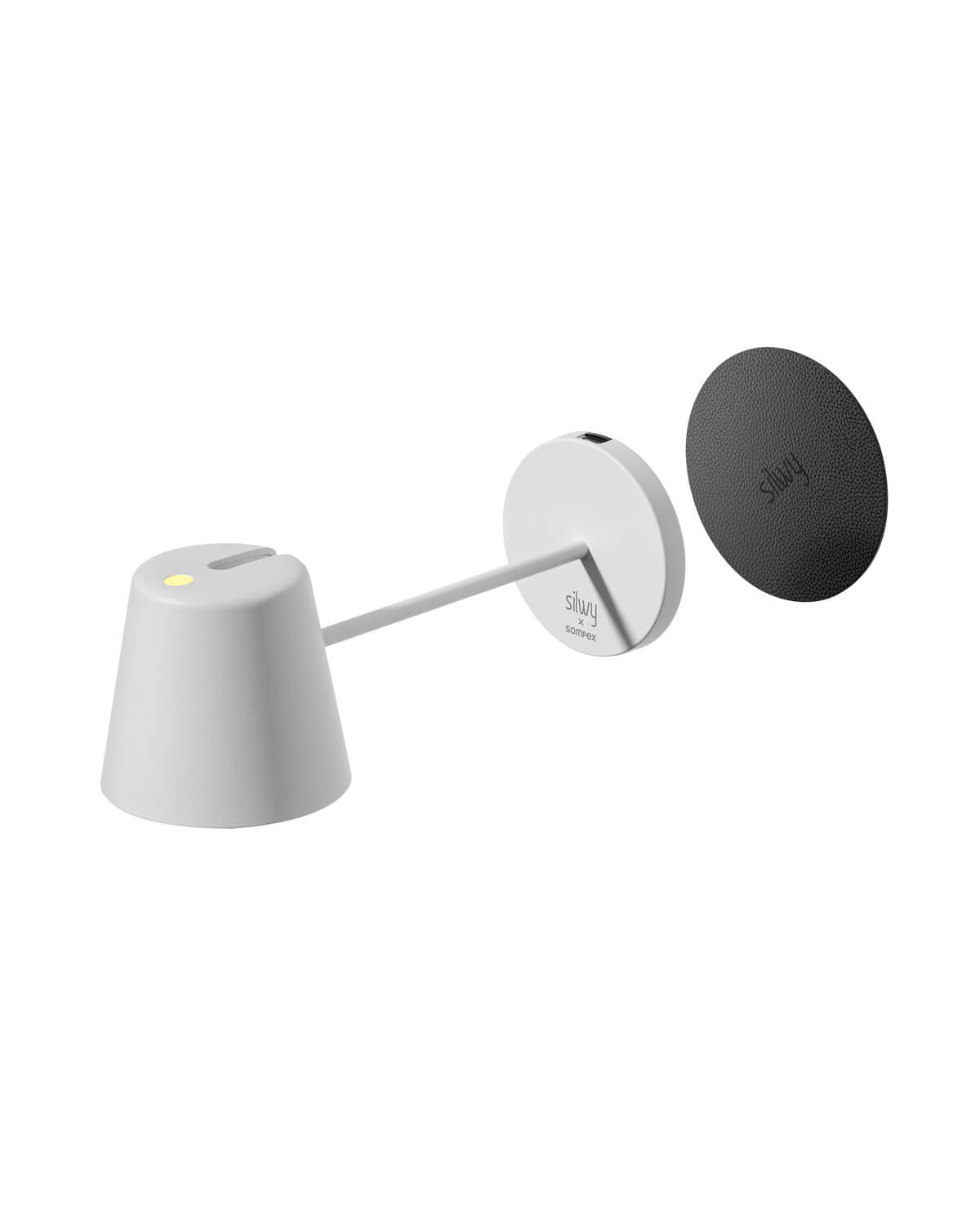 Vue éclatée montrant la lampe, sa base ronde et la pastille noire texturée.