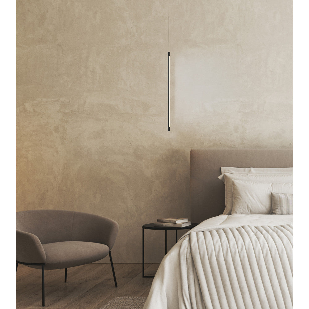Vue d'ensemble d'une chambre beige avec le luminaire suspendu près du lit