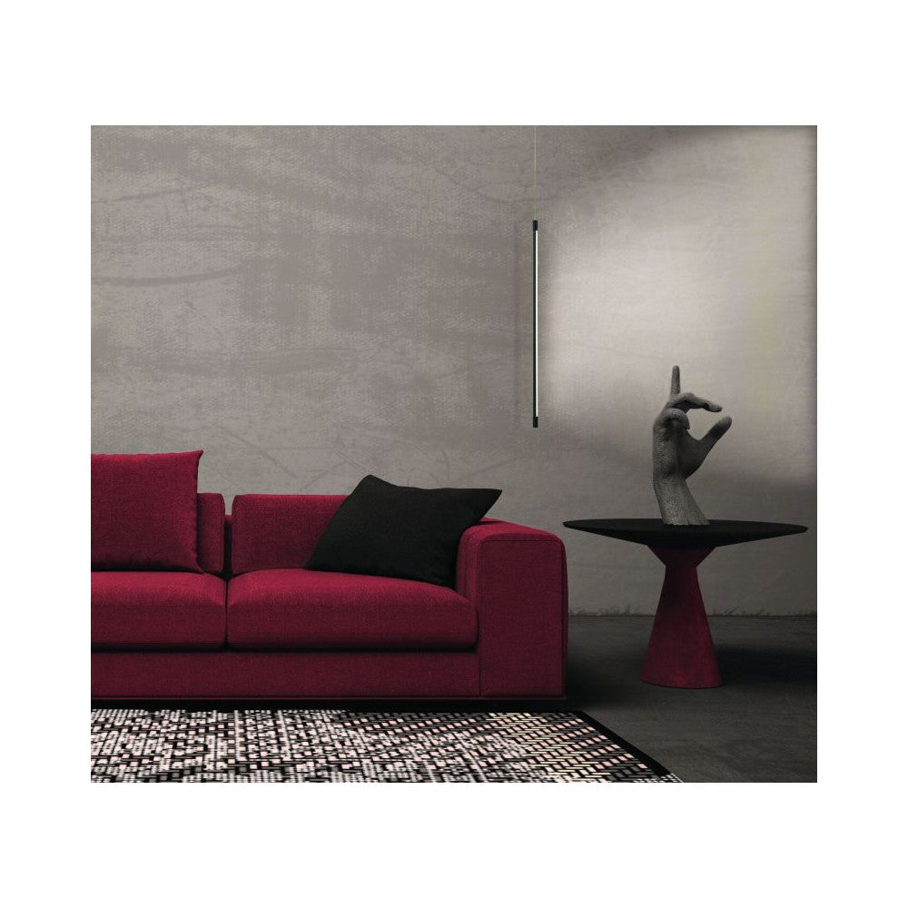 Suspension noire fine éclairant un salon avec canapé rouge et table basse