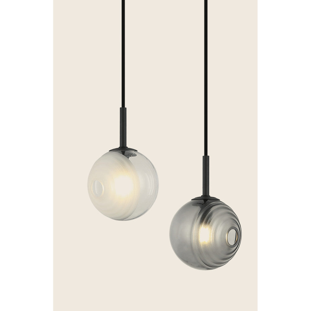 Détail rapproché des deux globes éclairés, mettant en valeur la texture du verre.