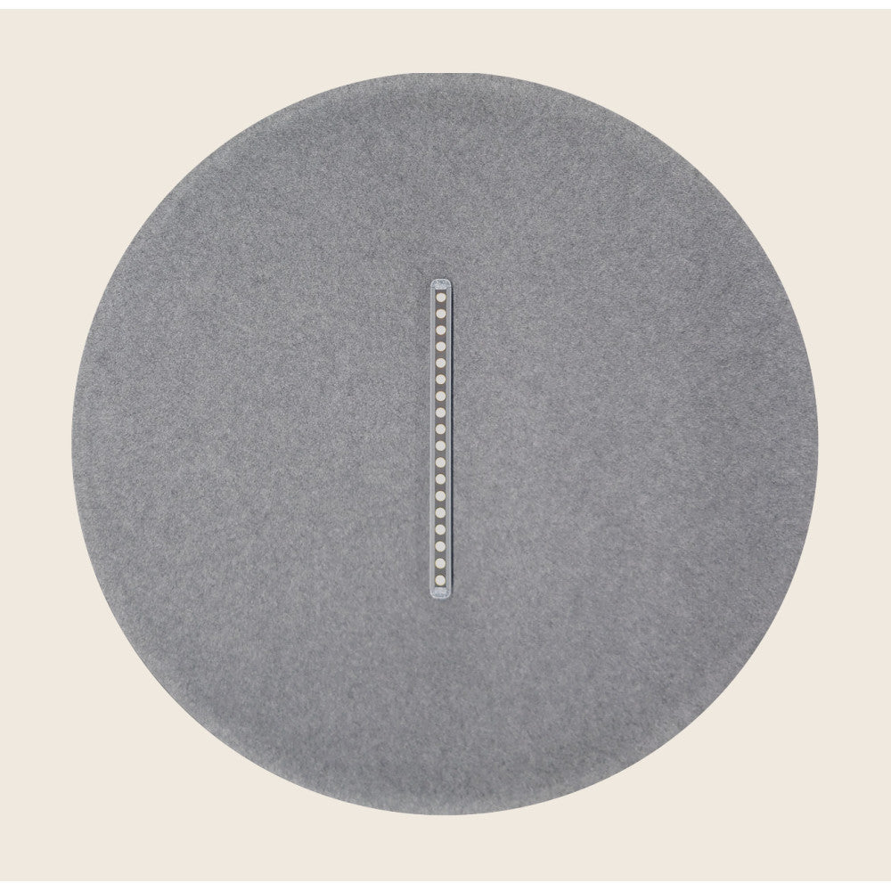 Détail du diffuseur rond gris et de sa barrette LED sur fond beige