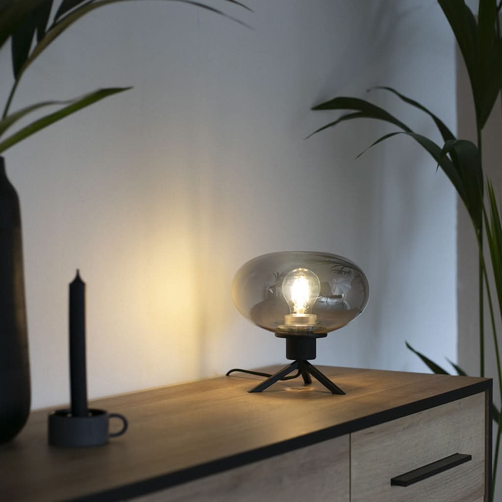 Mise en ambiance nocturne, lampe allumée diffusant une lumière chaude sur le meuble