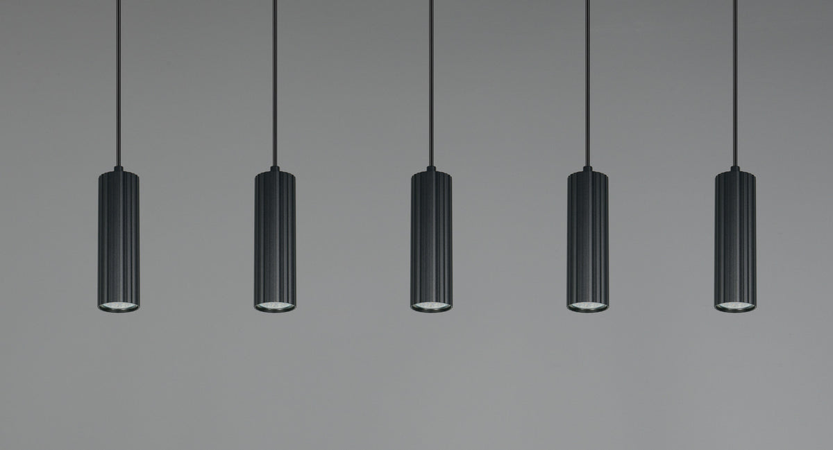 Vue rapprochée des cinq cylindres noirs cannelés suspendus sur fond gris.