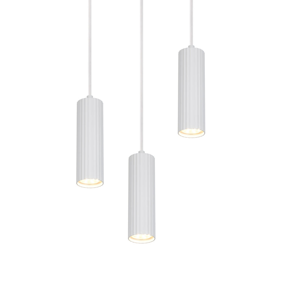 Les trois cylindres blancs cannelés allumés diffusant une lumière chaude vers le bas