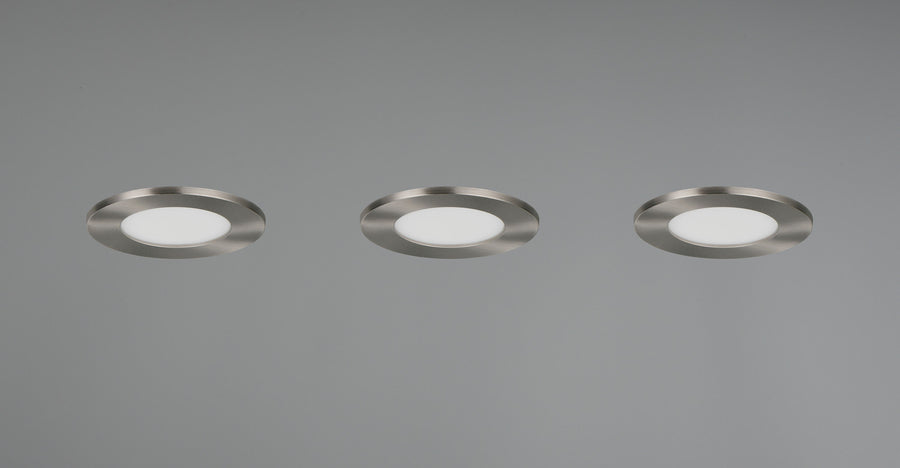 Trois spots encastrés au plafond gris, collerette nickel et diffuseur blanc, alignés.
