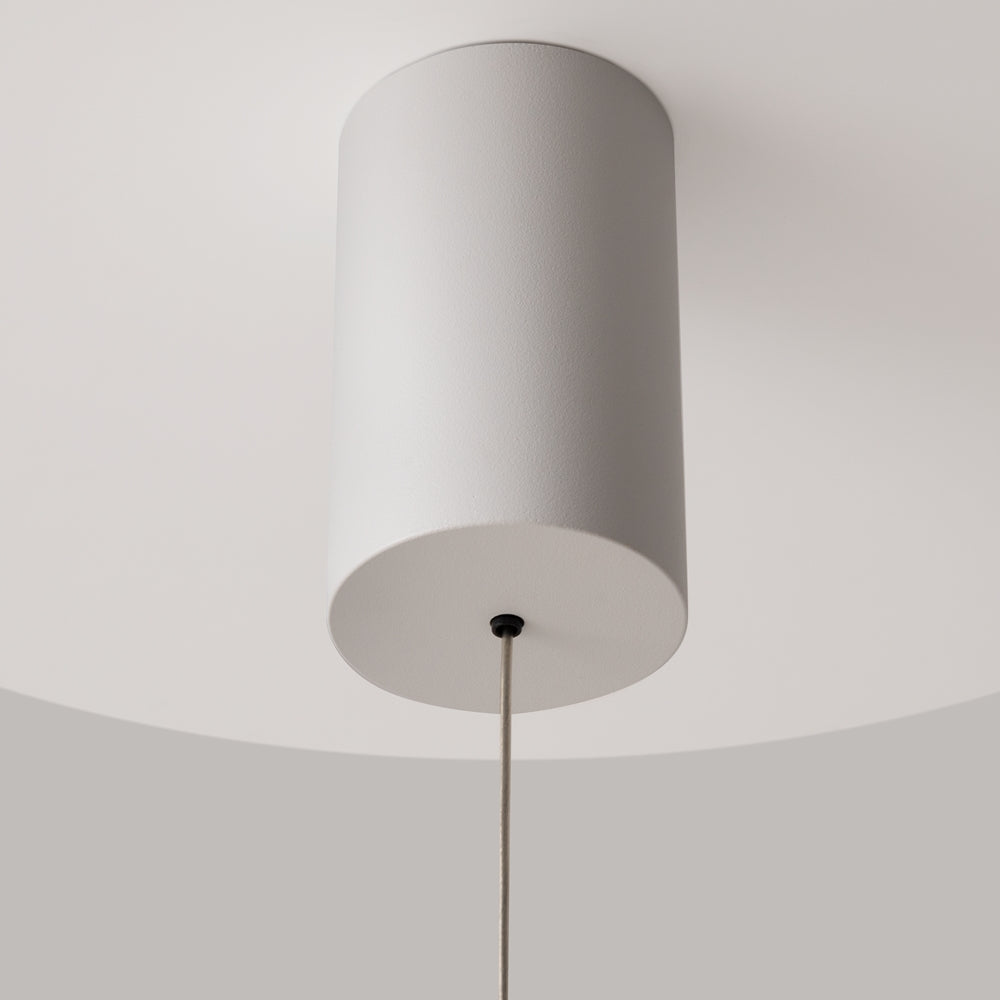 Détail de la rosace cylindrique blanche fixée au plafond et du câble
