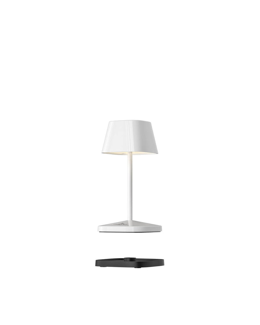Vue éclatée de la lampe blanche avec sa base de charge noire séparée.