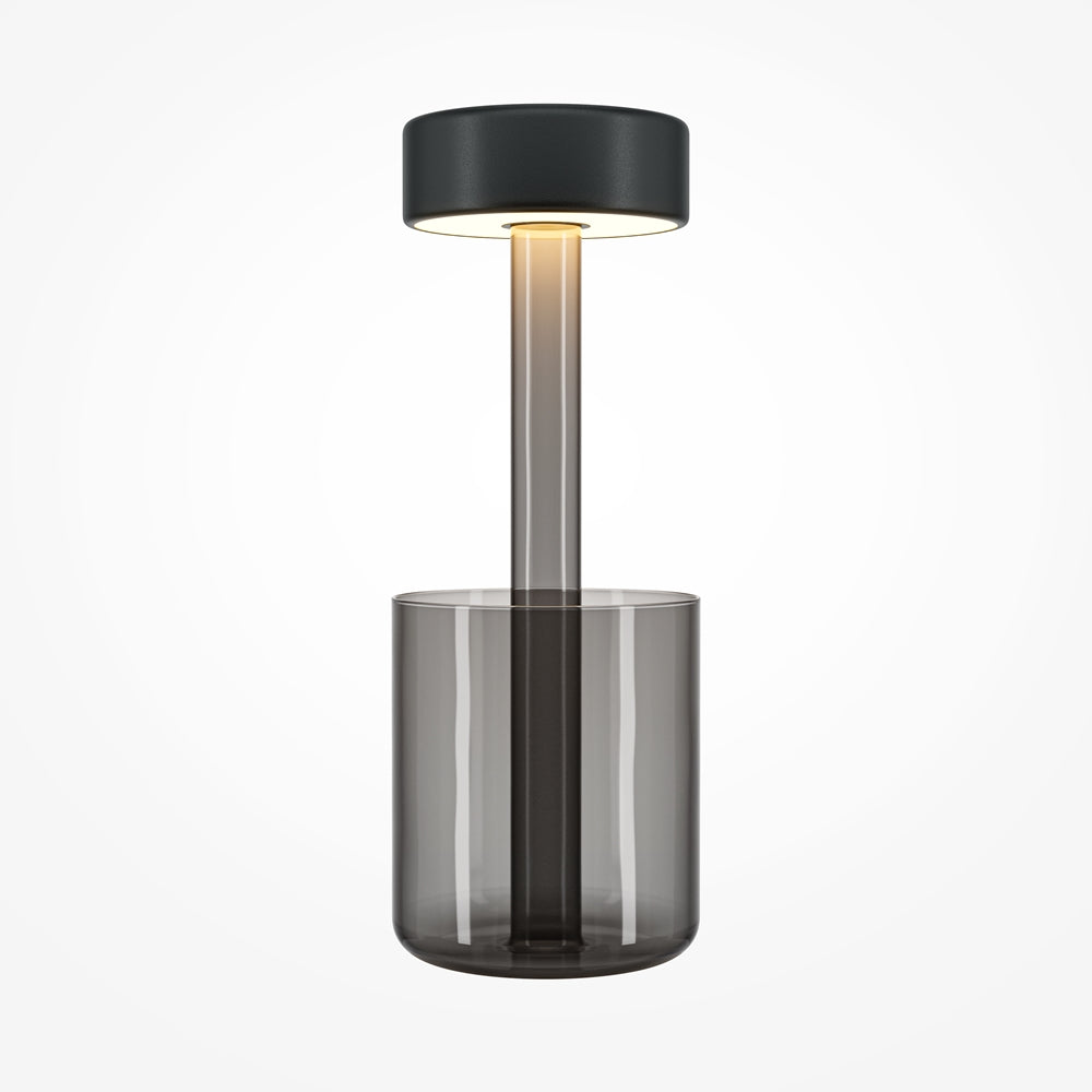 Lampe de chevet grise, face avant, verre fumé transparent, socle cylindrique et abat-jour noir.