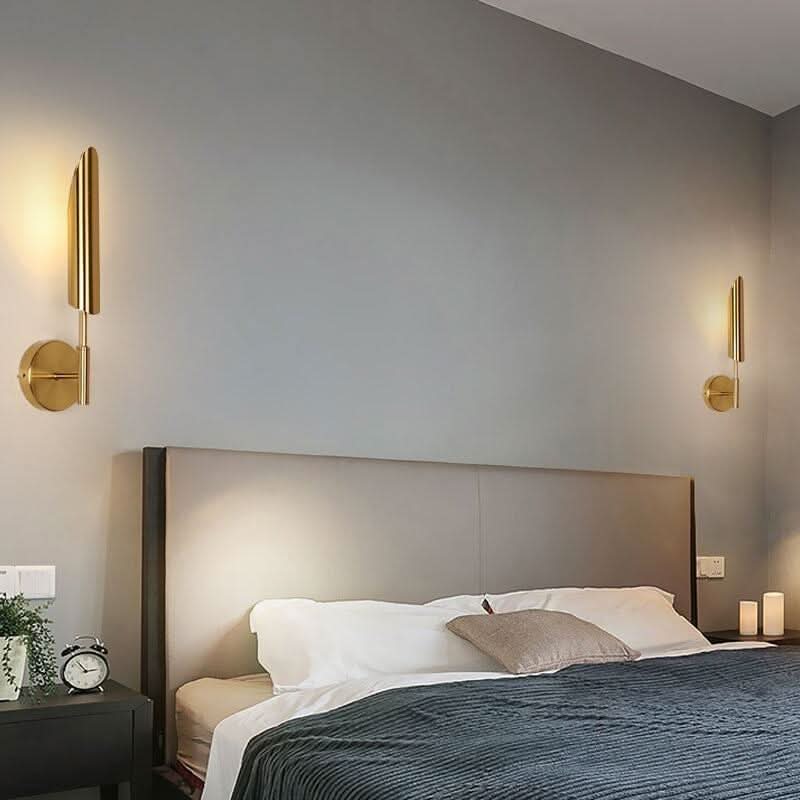 Deux appliques identiques encadrent la tête de lit dans une chambre aux tons gris.