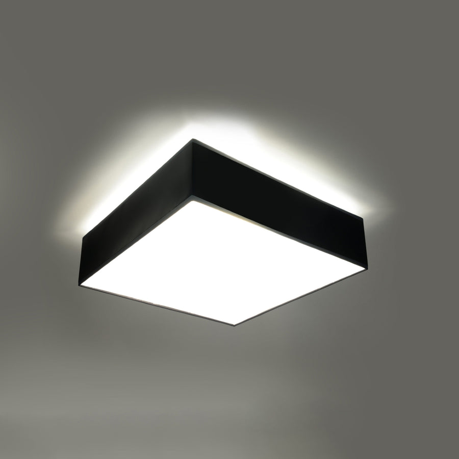 Plafonnier allumé au plafond avec halo lumineux diffus autour du cadre noir.