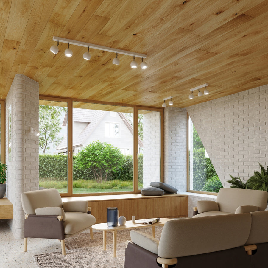 Mise en ambiance intérieure, plafond bois, deux rails de spots allumés au-dessus des fauteuils