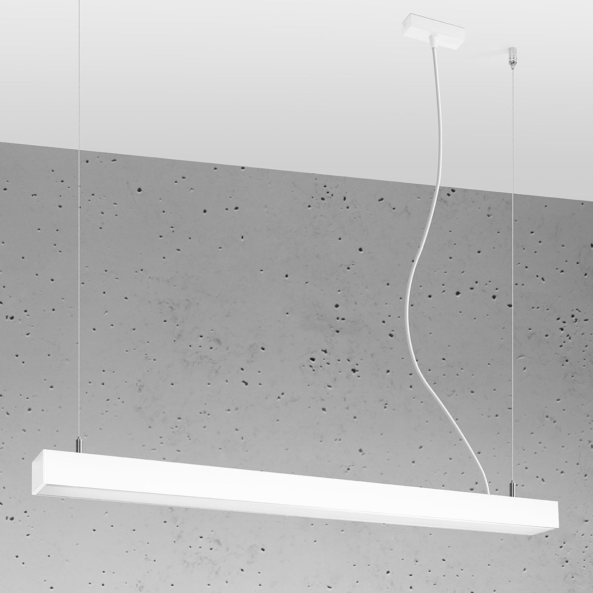 Lampe suspendue rectangulaire éclairée, installée devant un mur en béton brut