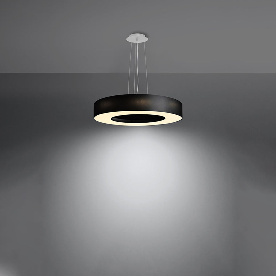 Luminaire suspendu allumé diffusant une lumière blanche dans une pièce sombre