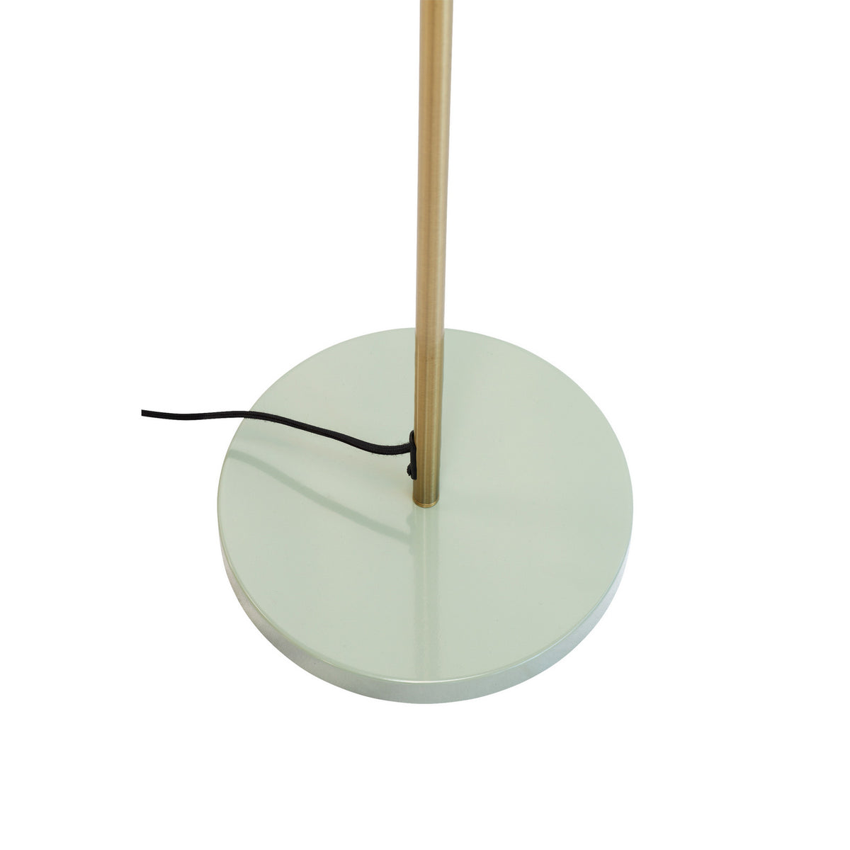 Détail de la base ronde vert clair, du fût laiton et du câble noir.