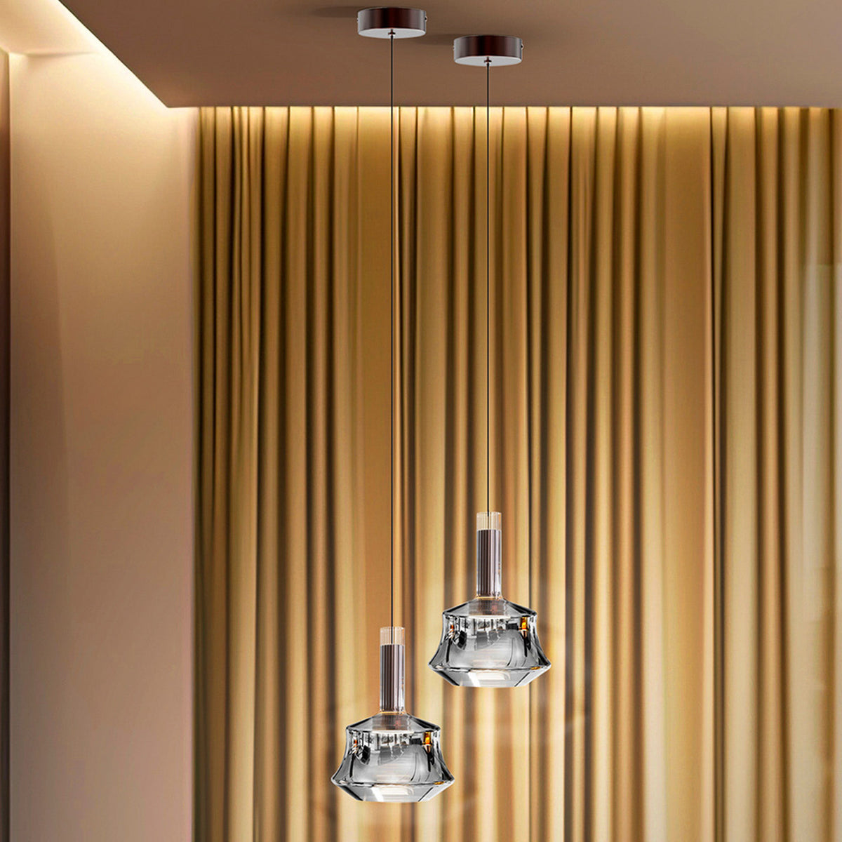 Gros plan sur deux suspensions en verre transparent aux détails métalliques bronze brossé.