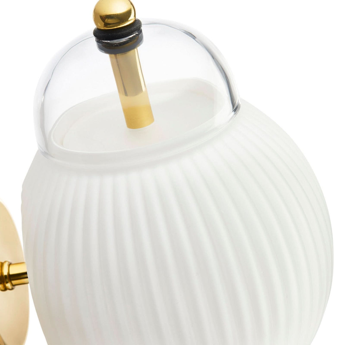 Gros plan du verre transparent supérieur, de la tige dorée et du joint noir.