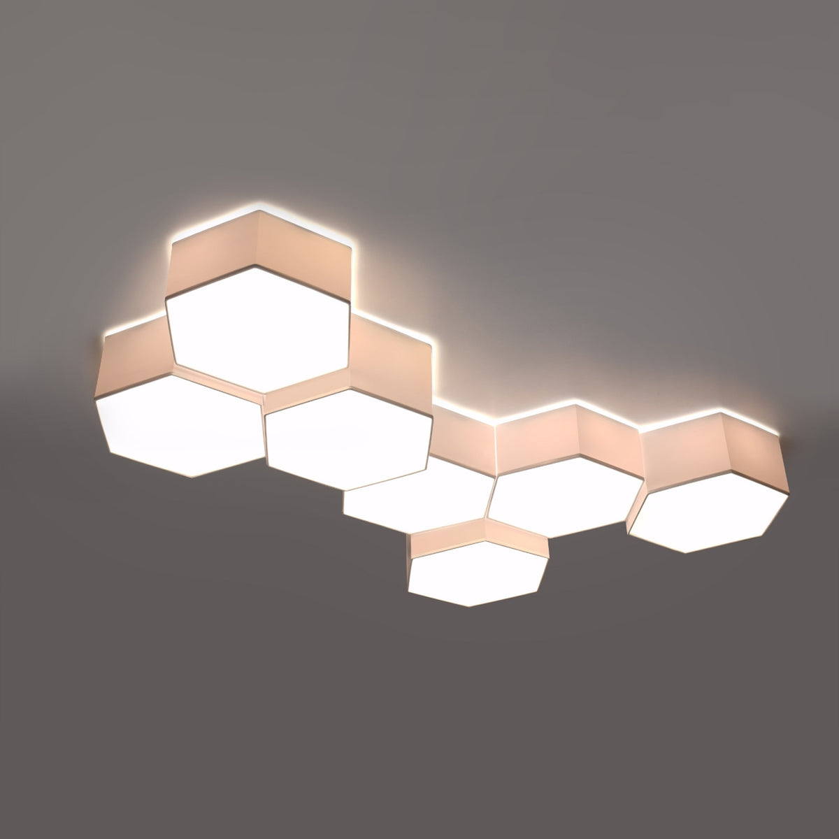 Grande composition de sept hexagones allumée, lumière chaude sur plafond gris