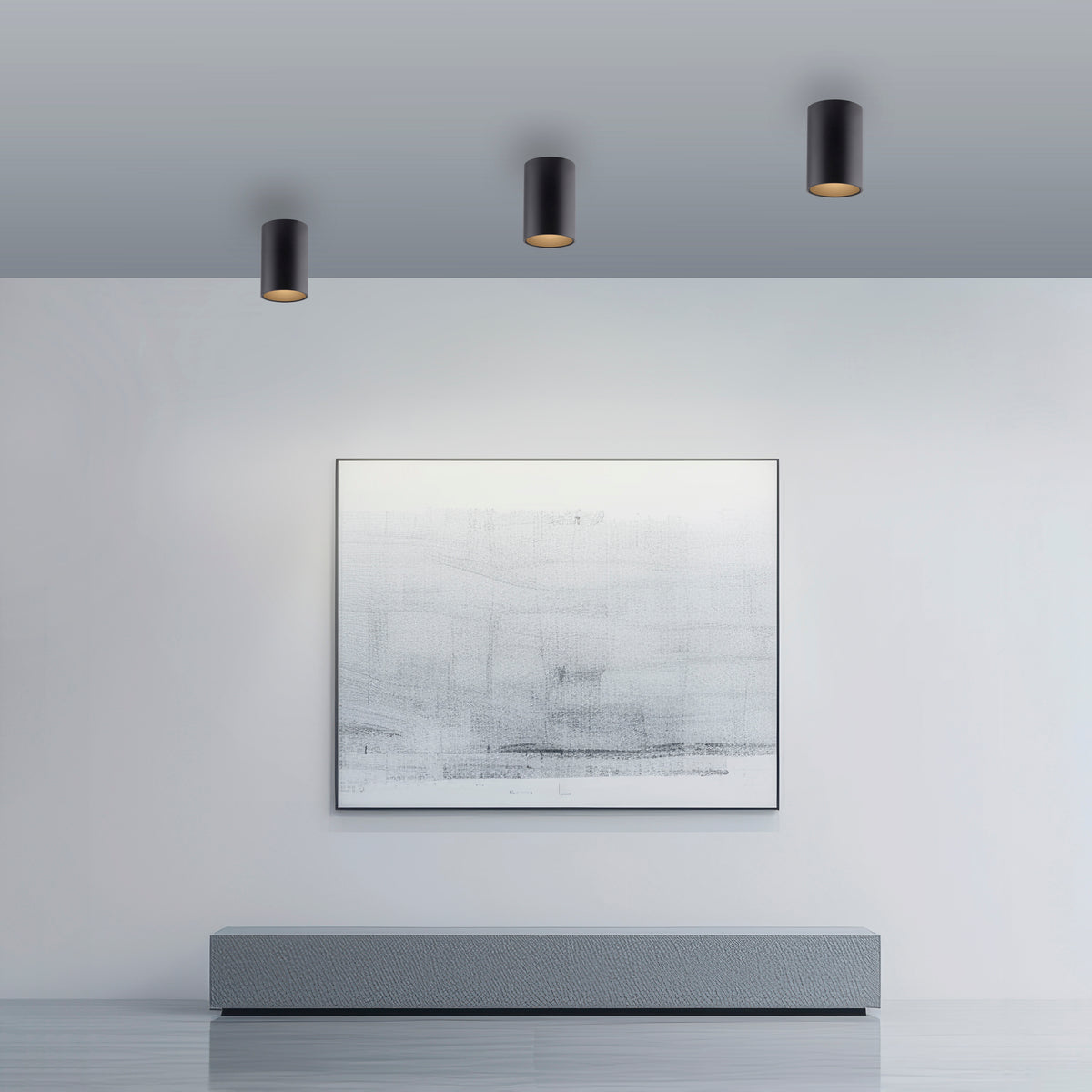 Mise en ambiance de trois plafonniers noirs au plafond au-dessus d'un tableau abstrait.