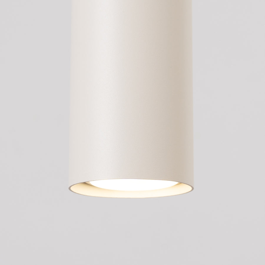 Détail du bas d'un cylindre allumé avec diffuseur blanc et halo lumineux.