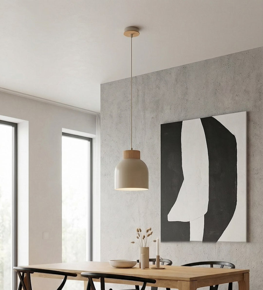 Luminaire suspendu au-dessus d'une table, mur béton et toile abstraite