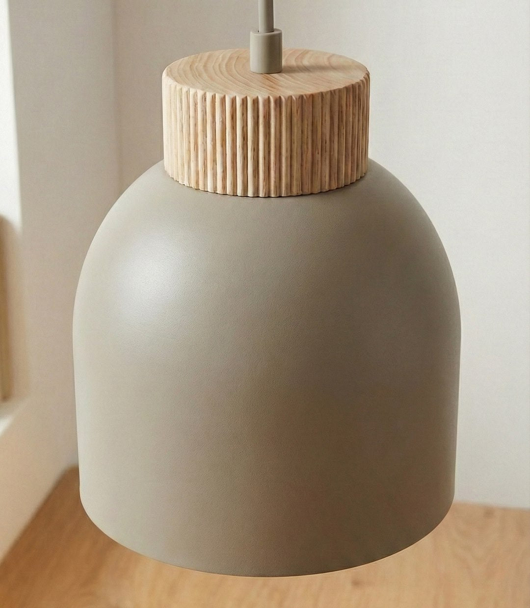 Gros plan sur un abat-jour beige et sa couronne en bois rainuré
