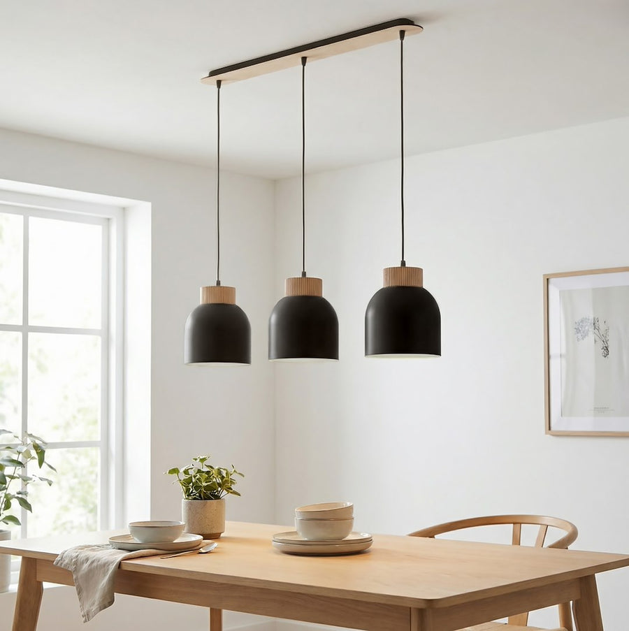 Luminaire suspendu au-dessus d'une table en bois dans une salle à manger claire