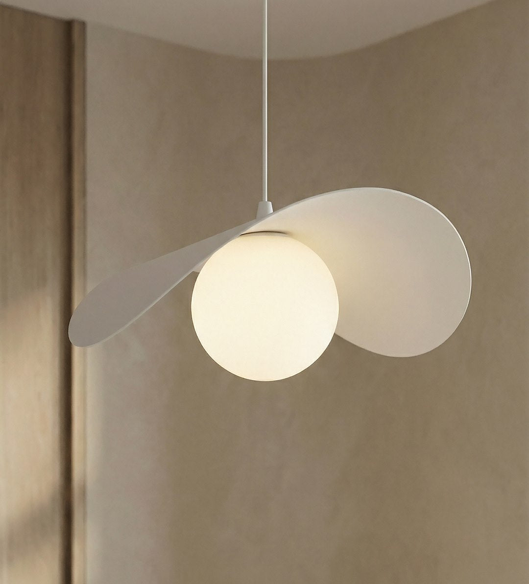 Détail rapproché du globe lumineux et des pétales blancs incurvés, suspension allumée.