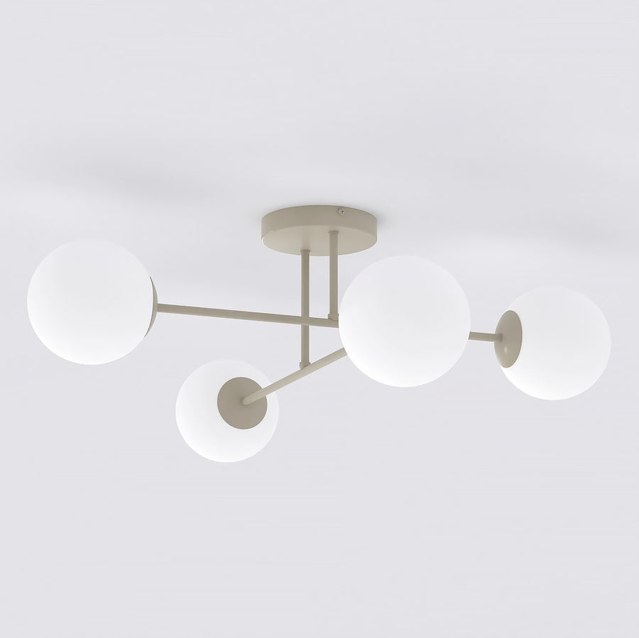 Plafonnier quatre globes en verre blanc opalin, bras beige croisés, fond blanc