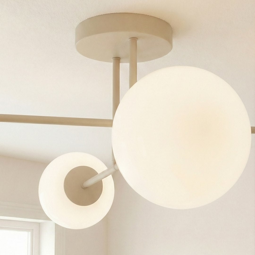 Détail rapproché d'une grande sphère de verre blanc et de son bras beige