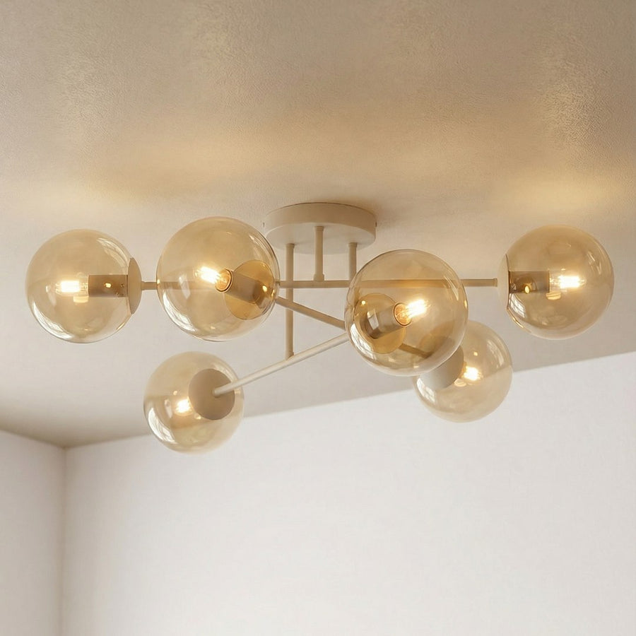 Vue rapprochée du plafonnier allumé, globes ambrés et reflets dorés